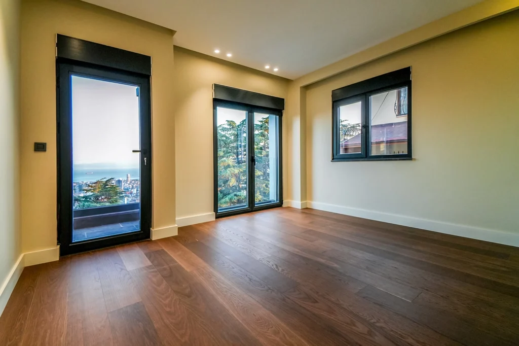 SRK Kartal Villa’da Manzaraya Açılan Aydınlık Oda SRK İnşaat’ın Kartal’da inşa ettiği villada cam kapılı, deniz manzaralı ve parke zeminli oda