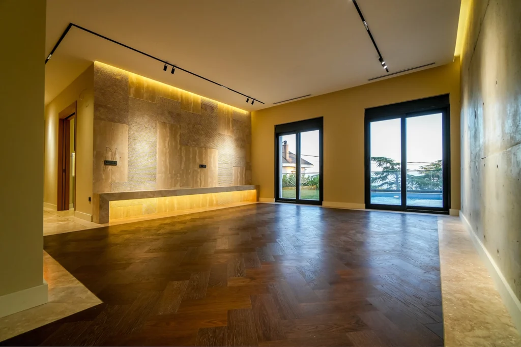 SRK Kartal Villa’da Aydınlatmalı Duvar Detaylı Geniş Salon SRK İnşaat Kartal Villa’da aydınlatmalı doğal taş duvarlı ve cam kapılı salon alanı
